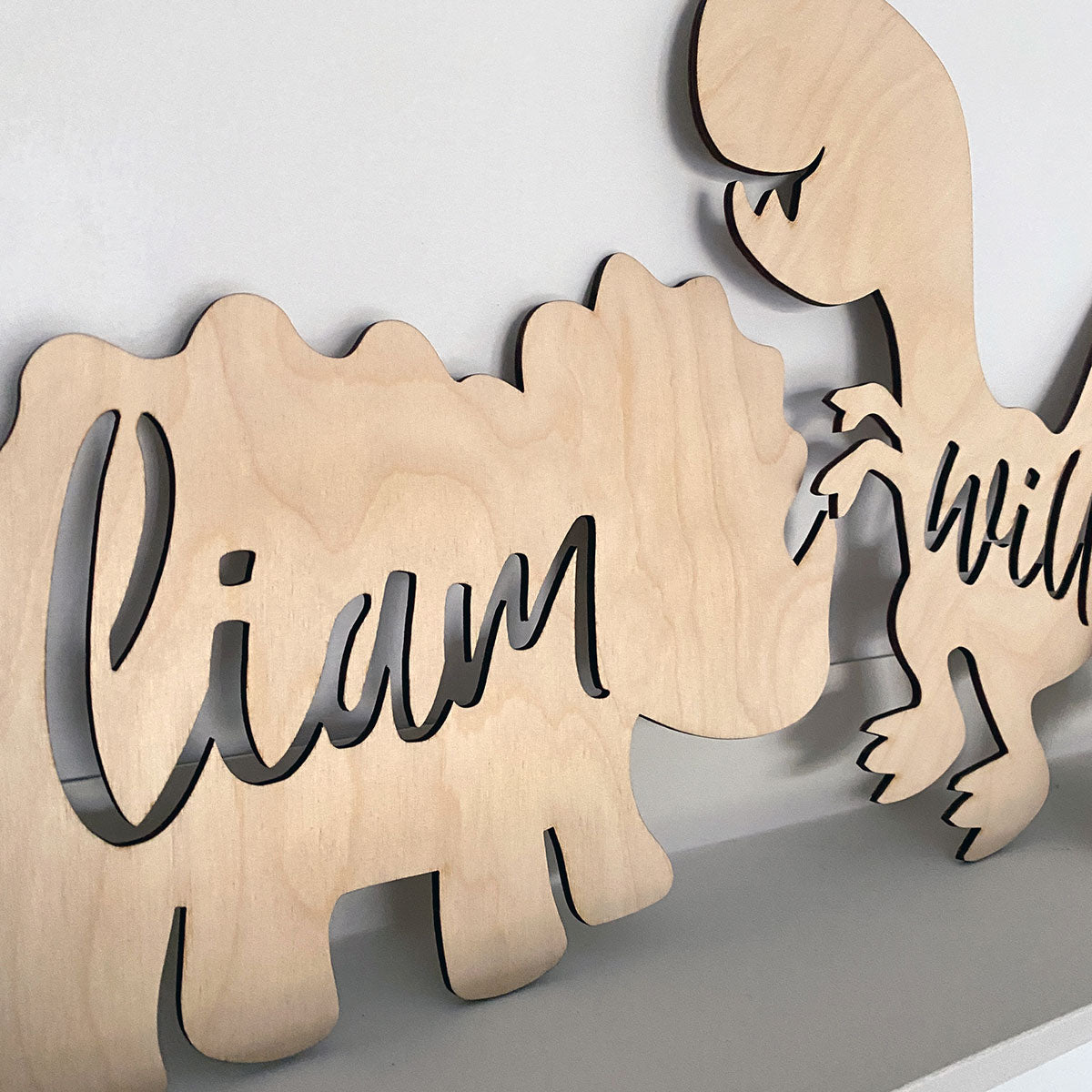Dinosaur Door Sign | Custom Name. Close up View of 2 dino signs showing quality of the birch plywood