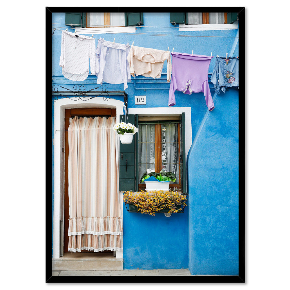 Bright Blue Terrace Washing Burano - Art Print by Victoria's Stories, Poster, Stretched Canvas, or Framed Wall Art Print, shown in a black frame