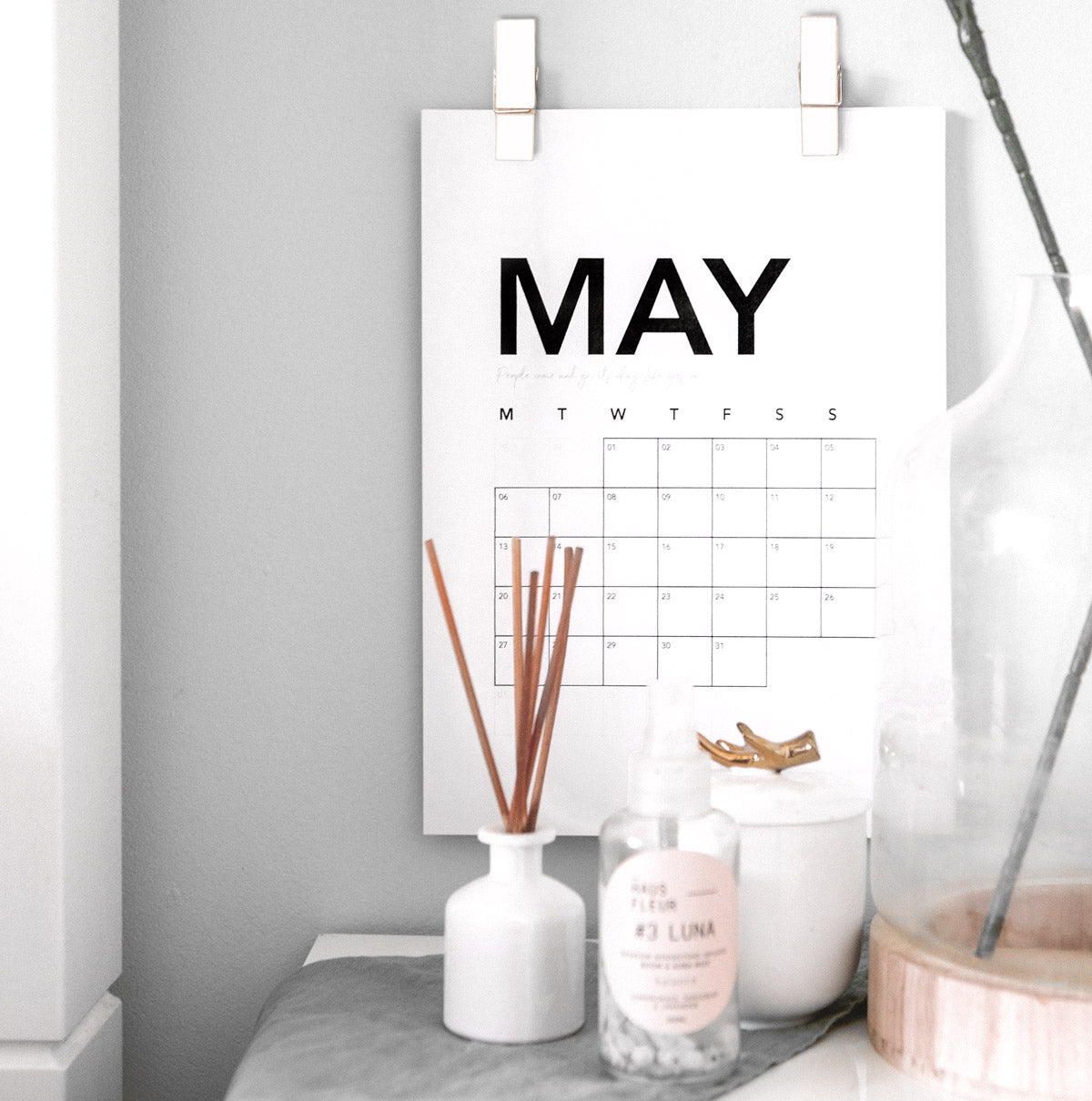 Pair of wooden spring clips on a wall, hanging a calendar