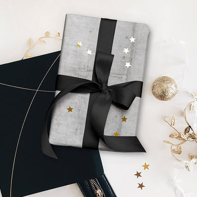 Concrete gift wrapping paper wrapped around a gift with black ribbon