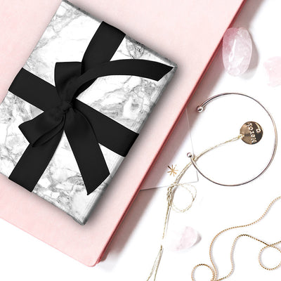 White Marble gift wrapping paper wrapped around a gift with black ribbon
